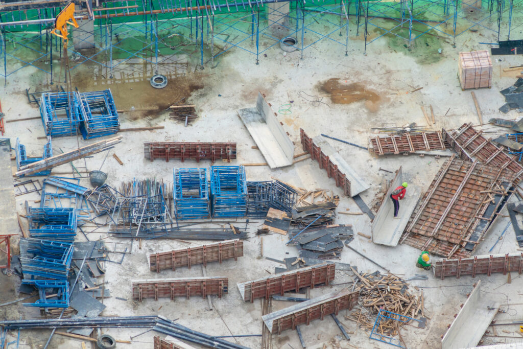 Aerial view of busy industrial under construction site workers working with cranes and excavators Top view of precast concrete slap floor full of steel Development high rise architecture building - Mallin Contracting